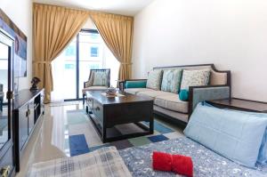 een woonkamer met een bank en een tafel bij A Comfy & Cozy Suasana Suites in Johor Bahru in Johor Bahru