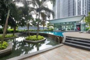 un complejo con una piscina con palmeras y un edificio en Modern 3BR Apt Near Desa Park Mont Kiara Parking, en Kuala Lumpur