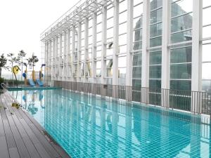 a large swimming pool next to a large building at A Comfy & Cozy Suasana Suites in Johor Bahru in Johor Bahru