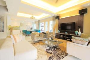a living room with a couch and a tv at A Spacious & Lux 4BR House with Gazebo in Cheras