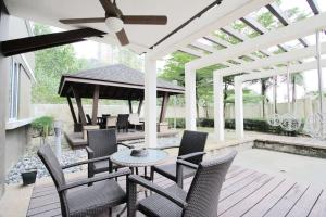 a patio with chairs and a table and a pergola at A Spacious & Lux 4BR House with Gazebo in Cheras