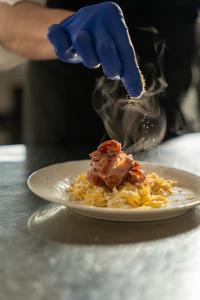 uma pessoa está a espalhar molho num prato de comida em Azienda Agrituristica Ai Prai em Castello di Godego