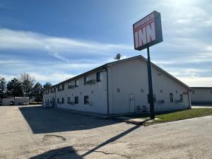 a white building with a sign in front of it at AINSWORTHINN in Ainsworth