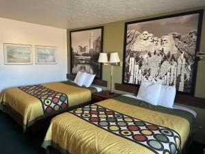 une chambre d'hôtel avec 2 lits et un tableau mural dans l'établissement AINSWORTHINN, à Ainsworth