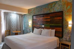 a hotel room with a large bed with a wooden headboard at La Concha Beach Hotel & Club in La Paz