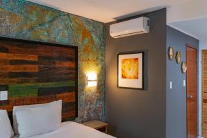 a bedroom with a bed and a painting on the wall at La Concha Beach Hotel & Club in La Paz