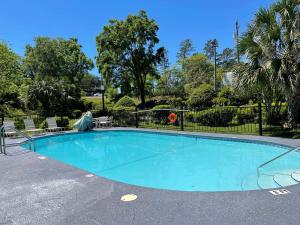 einen Pool mit Stühlen und einem Zaun in der Unterkunft Best Western Tallahassee Downtown Inn and Suites in Tallahassee