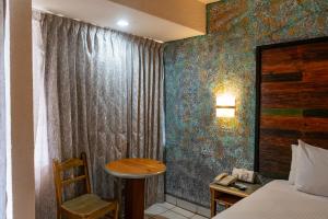 a room with a bed and a table and a desk at La Concha Beach Hotel & Club in La Paz