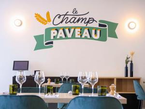 a table with wine glasses and a sign that reads be change raveay at Novotel Reims Tinqueux in Reims