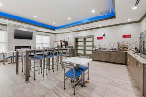 a restaurant with tables and chairs in a room at Best Western Plus First Coast Inn and Suites in Yulee