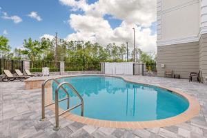 a swimming pool in the middle of a patio at Best Western Plus First Coast Inn and Suites in Yulee