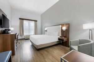 a hotel room with a bed and a chair at Best Western Plus First Coast Inn and Suites in Yulee +32 photos