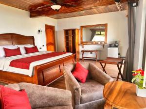 ein Schlafzimmer mit einem Bett und zwei Stühlen in einem Zimmer in der Unterkunft Hotel Trópico Monteverde in Monteverde Costa Rica