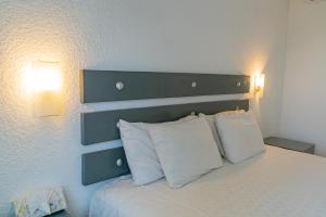 um quarto com uma cama com duas almofadas brancas em La Concha Beach Hotel & Club em La Paz