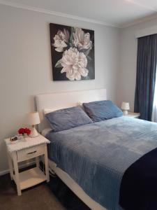 a bedroom with a bed with a blue comforter at Happy Space in Waihi