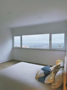 una stanza bianca con un letto e una finestra di Monte da Boavista ad Alcácer do Sal