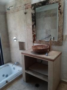W łazience znajduje się umywalka, lustro i wanna. w obiekcie Quinta Edén Cuernavaca w mieście Cuernavaca