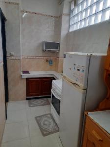 a small kitchen with a refrigerator and a sink at Maison tranquille in Boumerdes