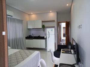 a room with a bed and a kitchen with a table at apartamento studio setor Sul in Palmas