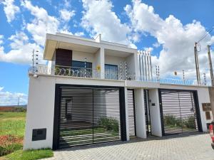une maison blanche avec deux portes de garage dans l'établissement apartamento studio setor Sul, à Palmas