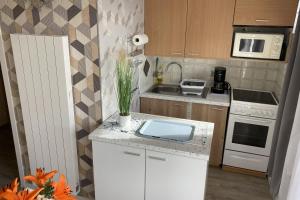 uma cozinha com um balcão branco e um lavatório em Apartment near the beaches of Villers-sur-Mer em Villers-sur-Mer