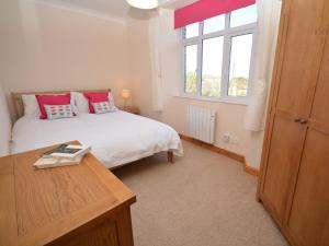 a bedroom with a bed and a desk and a window at 5 bed in Barnstaple SHIRW in Shirwell