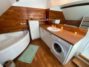 a bathroom with a washing machine and a sink at La Maison KDO in Châteauroux
