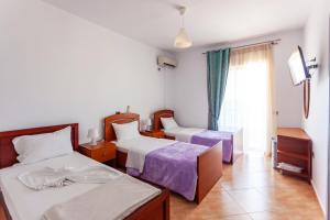 ein Hotelzimmer mit 2 Betten und einem Fenster in der Unterkunft Dhima Hotel in Himarë