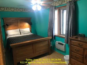 a bedroom with a bed and a blue wall at West Main Lodge, 3 bedroom in Lead