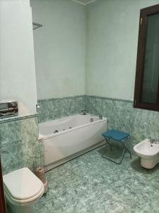 La salle de bains est pourvue d'une baignoire, de toilettes et d'un lavabo. dans l'établissement Dolce Risveglio vicino Milano, à Trezzano sul Naviglio