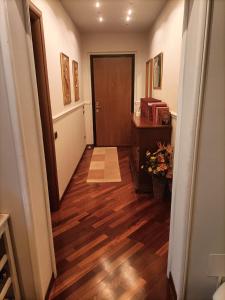 a hallway with a wooden floor and a door at Dolce Risveglio vicino Milano in Trezzano sul Naviglio