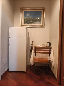 uma cozinha com uma mesa e um frigorífico branco em Dolce Risveglio vicino Milano em Trezzano sul Naviglio