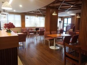 um restaurante com mesas, cadeiras e janelas em Manise Hotel em Ambon