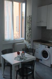 eine Küche mit einem Tisch und Stühlen sowie einer Waschmaschine in der Unterkunft NAVIGLIO 53 in Mailand