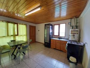 cocina con mesa y cocina con fogones en El Refugio Casa de Montaña en San Martín de los Andes