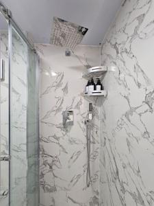 um chuveiro na casa de banho com uma parede em mármore em Comfortable Two Bedroom Flat em Brighton & Hove