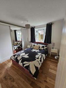 um quarto com uma cama com um cobertor preto e branco em Comfortable Two Bedroom Flat em Brighton & Hove