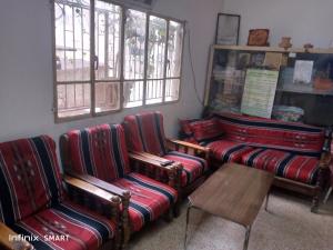 Habitación con sofás, mesa y ventanas. en Al Amawi Hostel, en Amán
