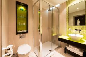a bathroom with a shower and a toilet and a sink at Hotel Indigo London Hyde Park Paddington, an IHG Hotel in London