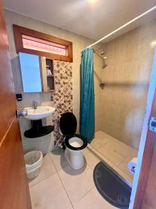 a small bathroom with a toilet and a sink at Juanchos House Hostel Tayrona in Los Naranjos