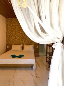 um quarto com uma cama com uma cortina em • Suíte Palmas • À Beira-Mar - Ilha Grande RJ® em Praia de Palmas