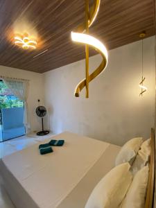 1 dormitorio con cama blanca y techo de madera en • Suíte Palmas • À Beira-Mar - Ilha Grande RJ® en Praia de Palmas
