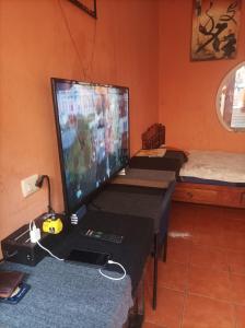 a computer monitor sitting on a desk with a gaming system at Hospedaje Marlenis in Managua