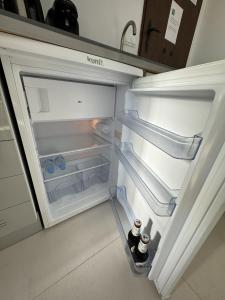 an open refrigerator with two bottles of water in it at Peaceful studio with amazing sea views and free parking in Benalmádena