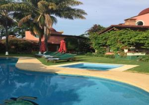 - une piscine avec des chaises et des parasols à côté d'une maison dans l'établissement Casa Shambhala Malinalco, à Malinalco
