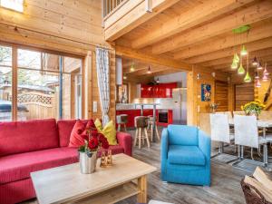カプルーンにあるLuxury Lodge Kaprun Ost Bの赤いソファとテーブルのあるリビングルーム