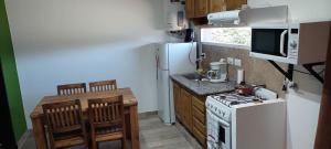 a small kitchen with a white refrigerator and a stove at Abuela Greta in Sierra de la Ventana