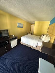 a hotel room with a bed and a flat screen tv at Welcome Inn in North Kingstown