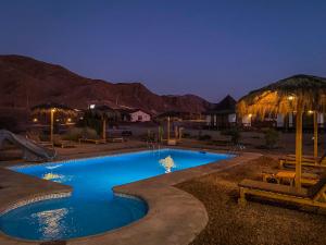 a swimming pool in the middle of a desert at night at Cabañas Caleta Hueso in Taltal