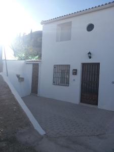 a white building with a door on the side of it at EL RINCON DEL ROMERAL in Pegalajar